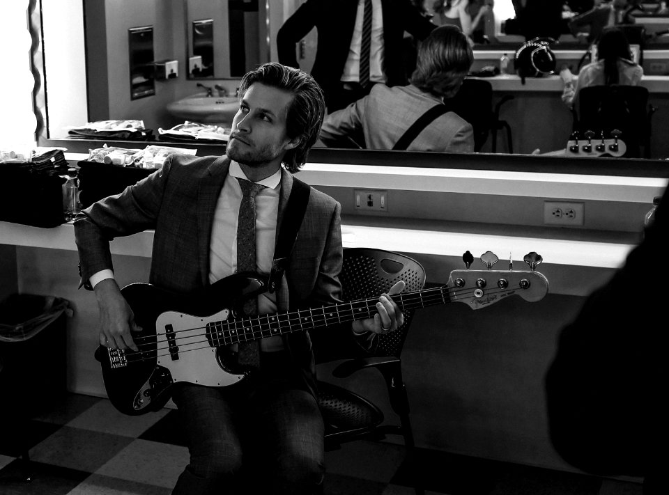grayscale photography of man wearing suit holding guitar photo