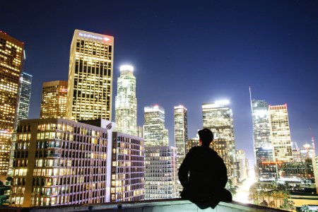 man sitting on rooftop during nighttime photo