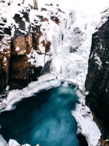 snow covered rock formation beside body of water photo
