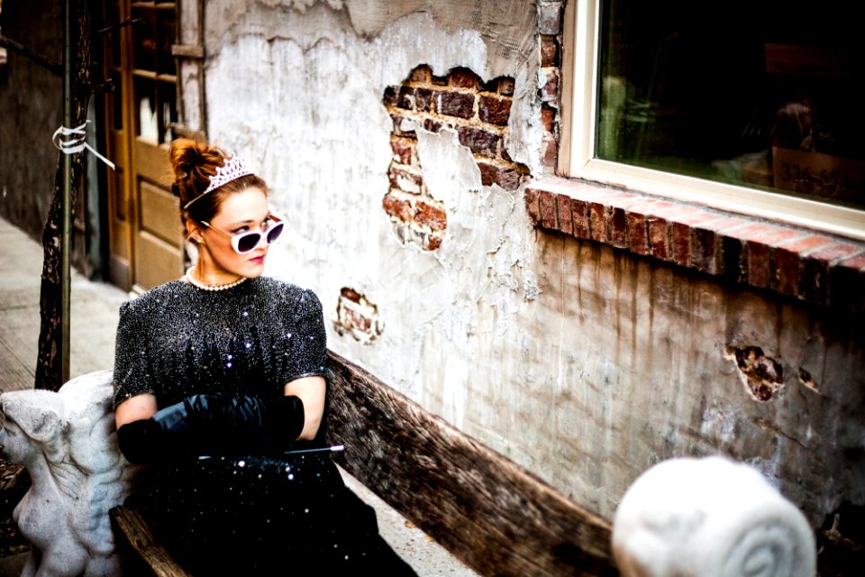 woman sit on bench facing on concrete wall