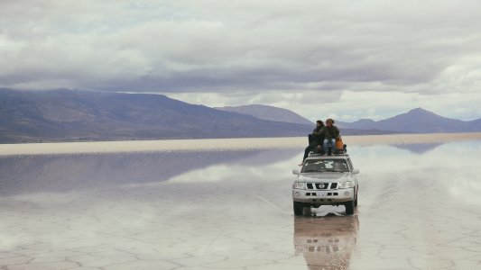 people on silver vehicle under gray sky during daytime photo