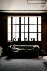 photo of person laying on sofa near window photo