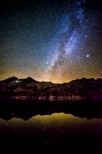starry night sky over the mountain by the glassy lake photo