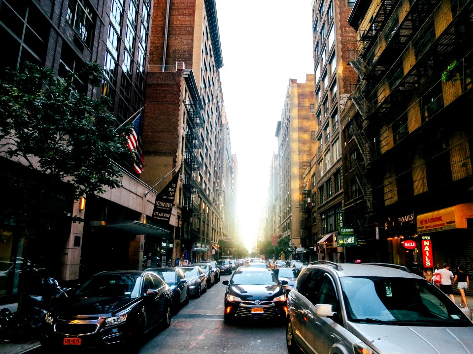 different vehicles on road viewing city with high-rise buildings