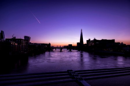 silhouette of buildings beside body of water photo