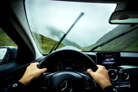 person driving Mercedes-Benz car during daytime