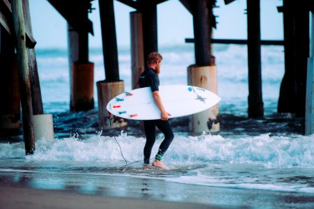 man holding white surfboard photo
