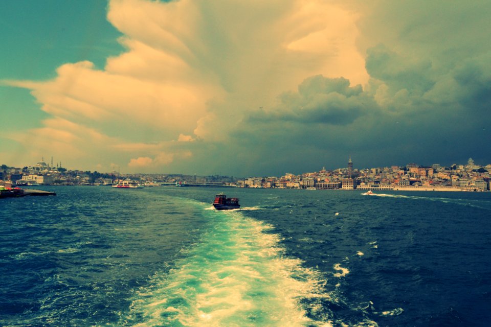 boat on body of water under cloudy blue sky