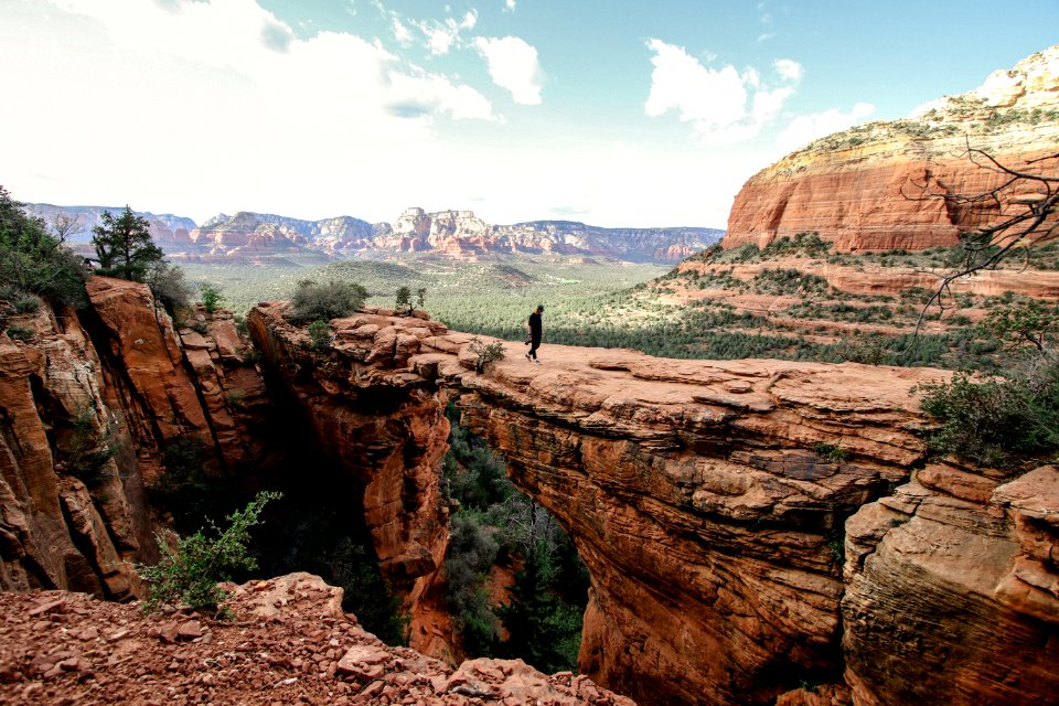 person standing on brown rock formation during daytime
