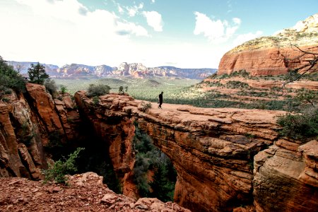 person standing on brown rock formation during daytime photo
