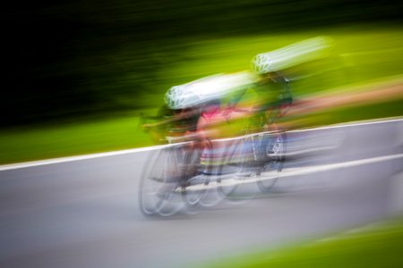 motion photography of two men riding mountain bikes