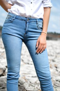 woman standing wearing jeans and white top photo