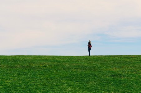 person standing on green grass field photo