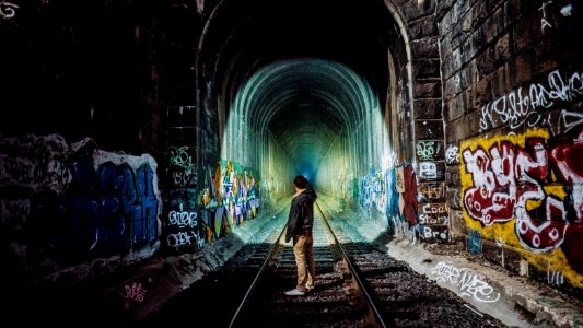 man standing near tunnel photo