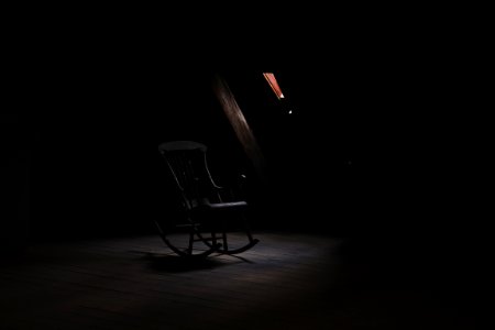 brown wooden rocking chair inside dark room photo
