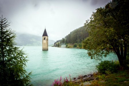 concrete tower surrounded by water near land with trees