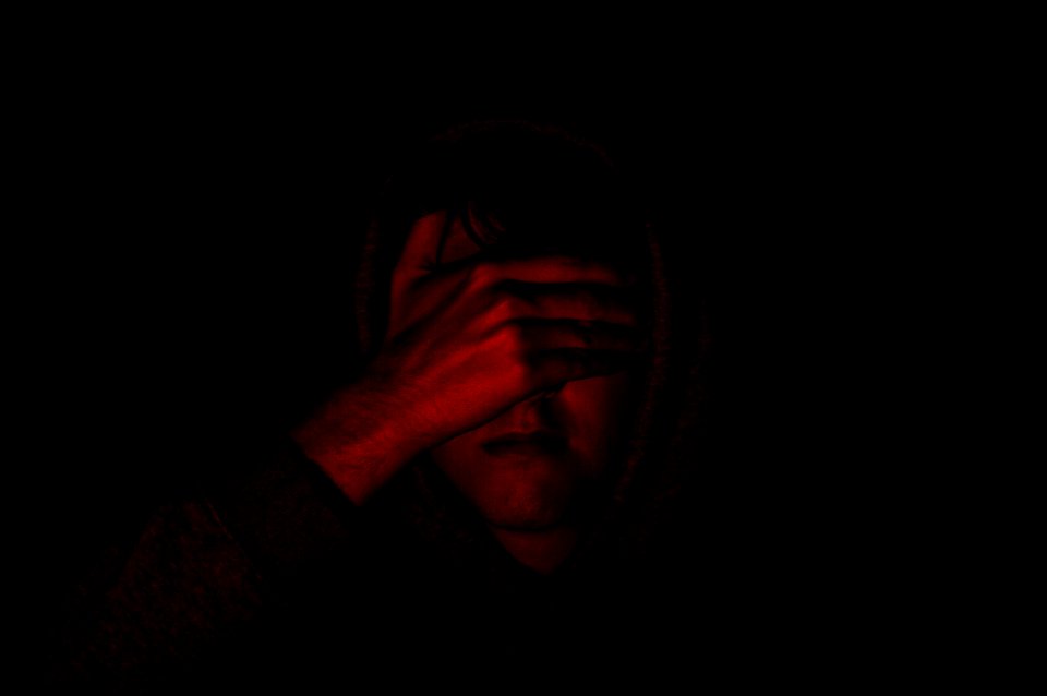 person covering face with right hand