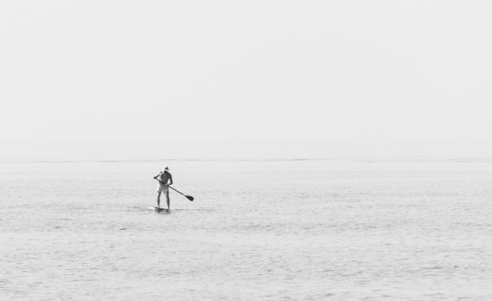 man standing on paddleboard photo