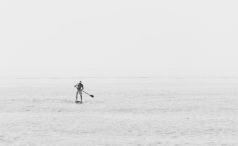 man standing on paddleboard photo