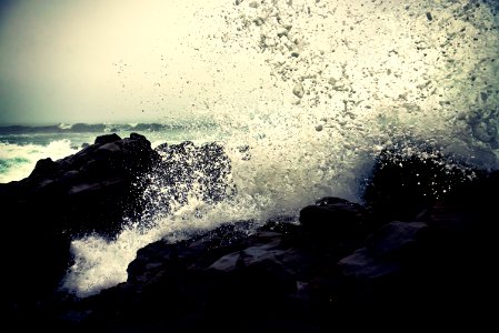 grayscale photography of ocean waves crashing on rock during daytime photo