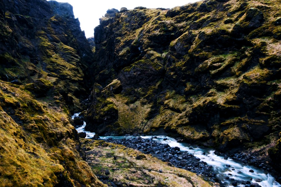 stream by rocks during daytime