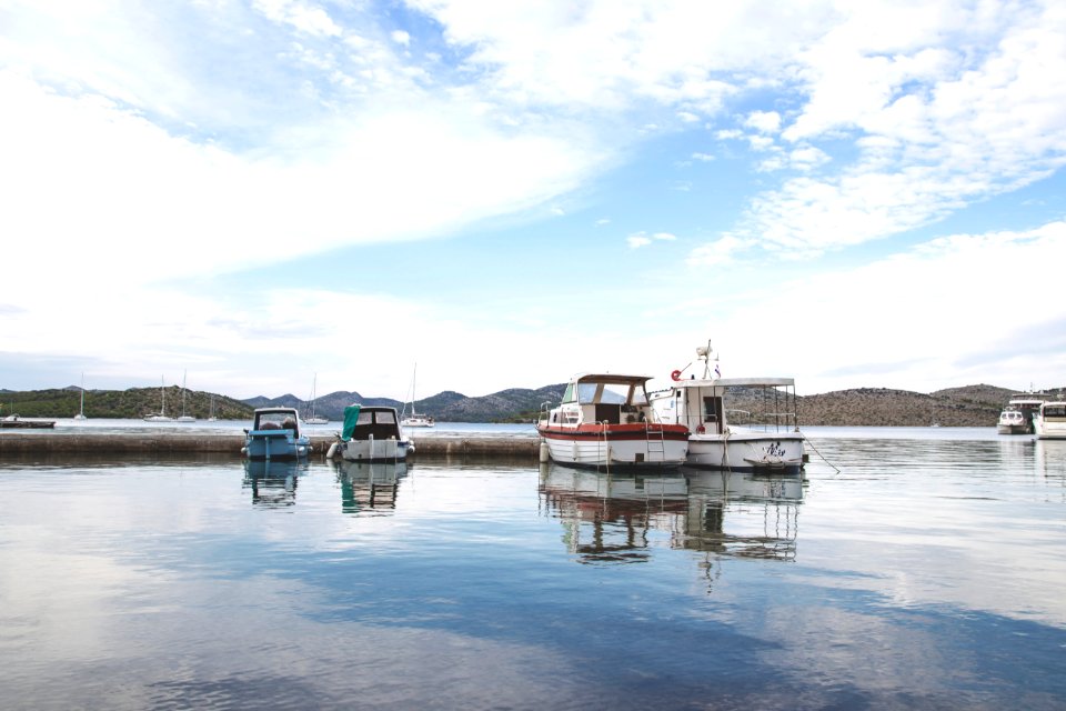 white and red boat on water under blue sky during daytime photo