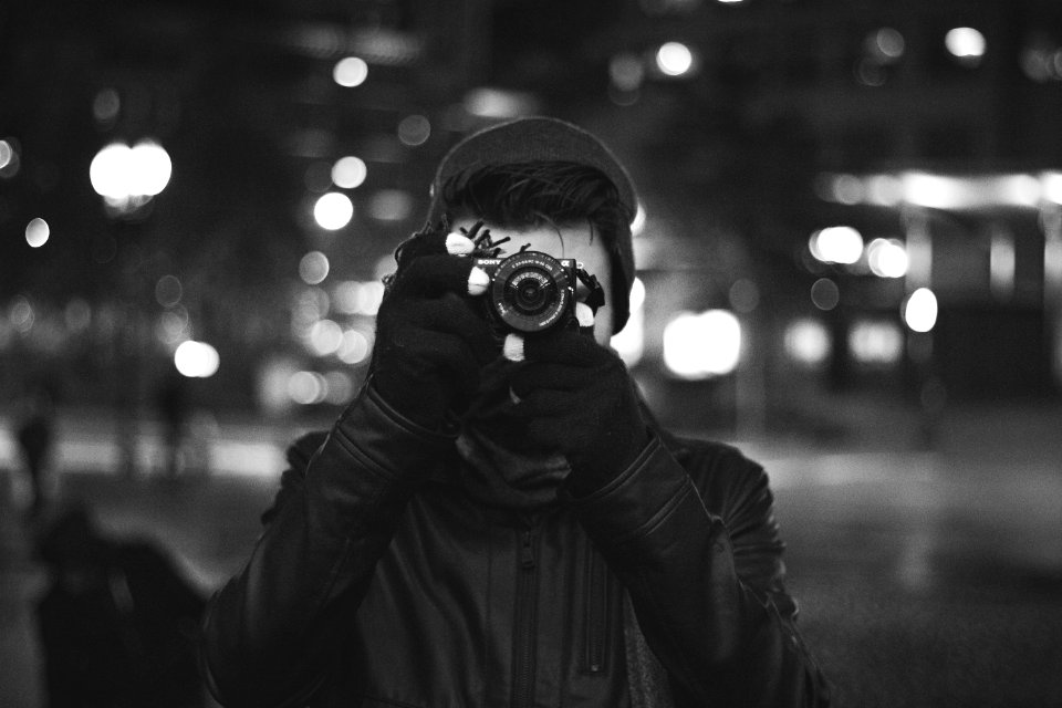 grayscale photo of a man taking a photo