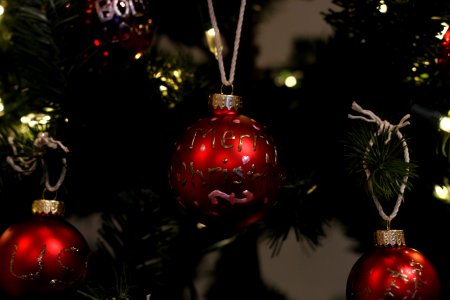 Red ornaments hanging from a Christmas tree. photo