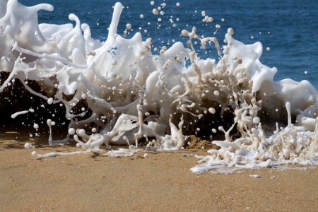 White milky waves hitting the beach sand. photo