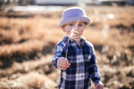 selective focus photography of boy standing near outdoor during daytime photo