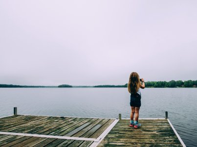 woman standing on brown wooden dock photo