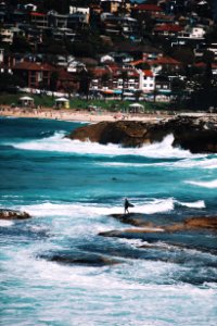 person carrying surfboard standing on shore photo