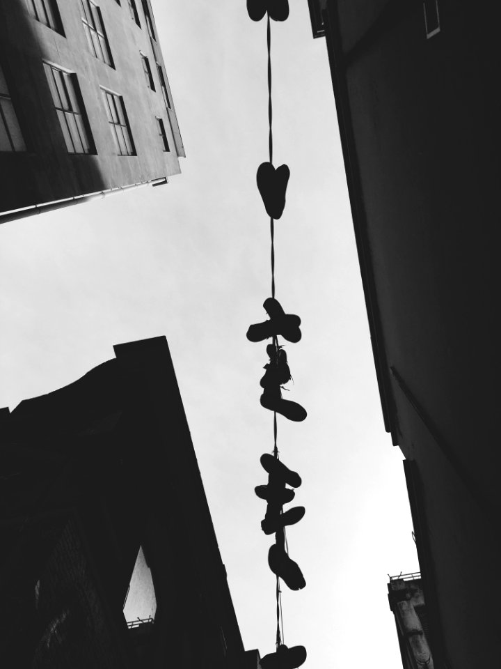 A clothesline with clothespins hung from large residential buildings.