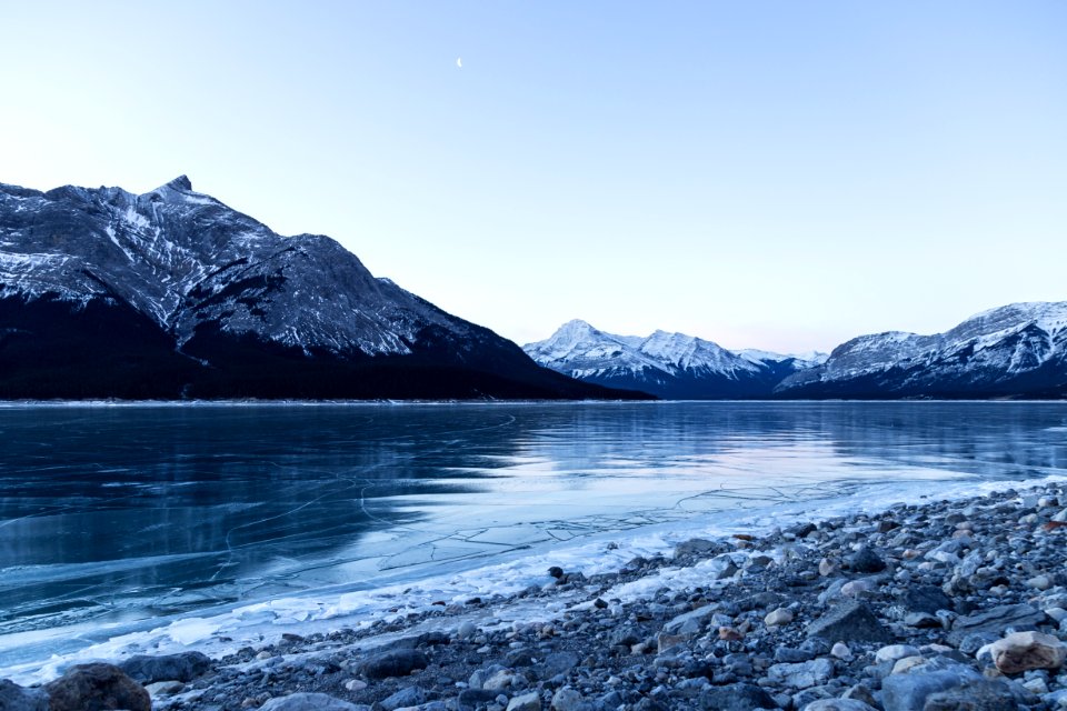 body of water surrounded with snowy mountain
