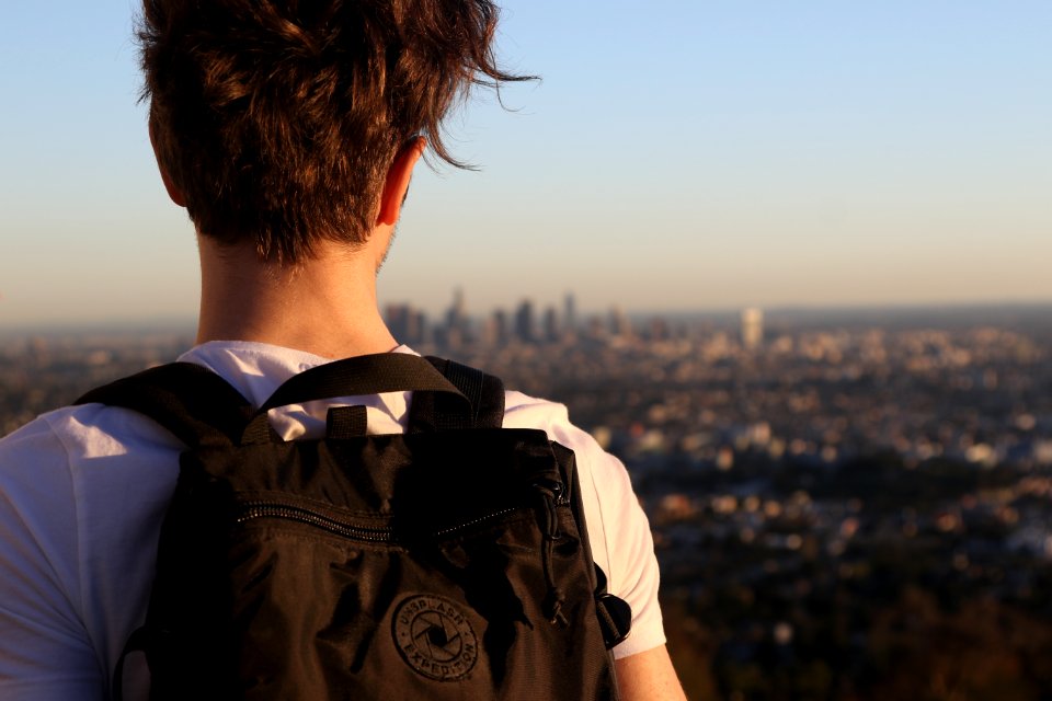 man wearing backpack on high ground