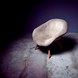 brown bucket chair near wall