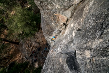person climbing on gray rock formation at daytime photo