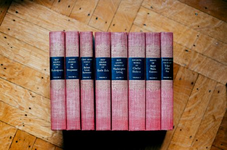 pile of red hardbound books on brown panel photo