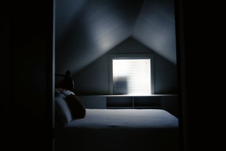 white bed frame beside attic window photo