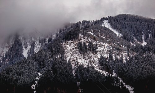 grayscale photography of snowy mountain covered by clouds photo