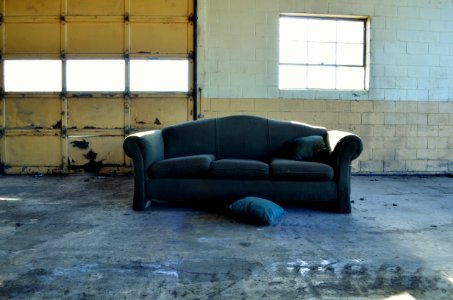 black fabric 3-seat sofa in front of wall and garage door