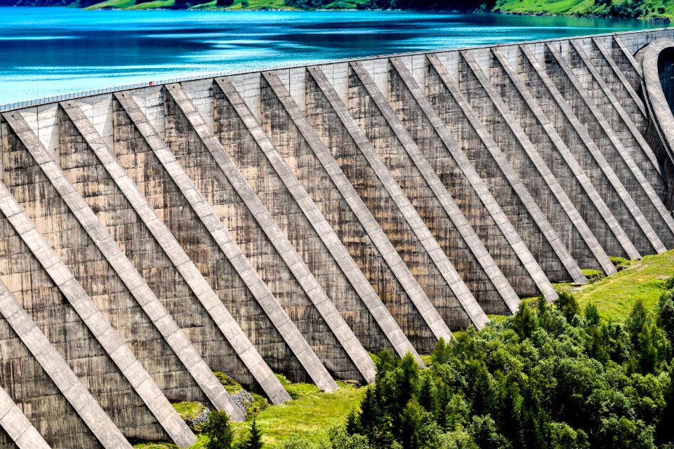 gray concrete dam near green trees