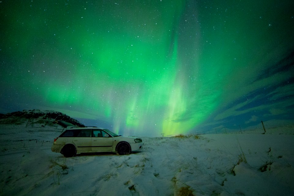 white station wagon under aurora borealis