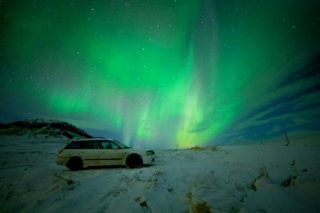 white station wagon under aurora borealis