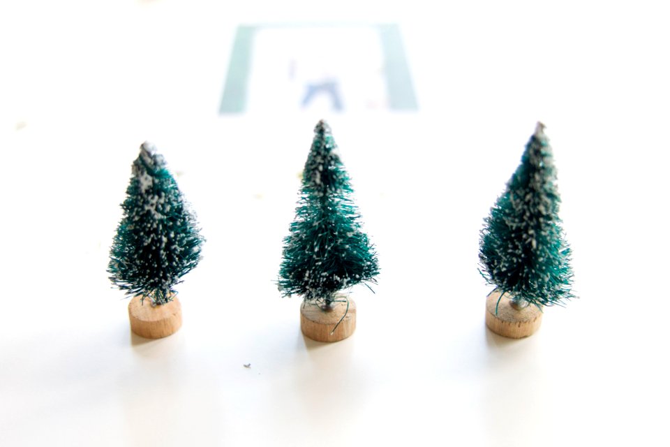Three little pretend Christmas trees on a table.