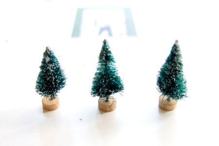 Three little pretend Christmas trees on a table.