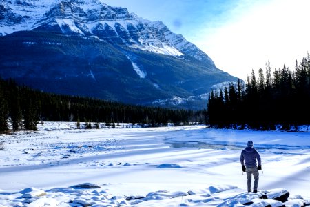person standing on snow near mountain during daytime photo