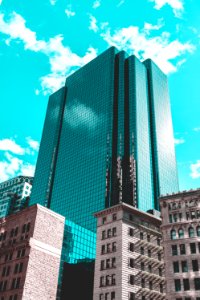 blue curtain wall building under teal skies
