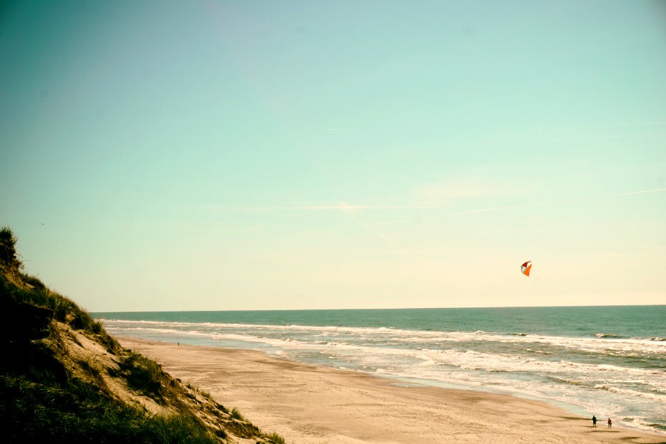 person flying kite on seashore