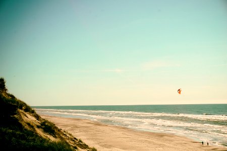 person flying kite on seashore photo